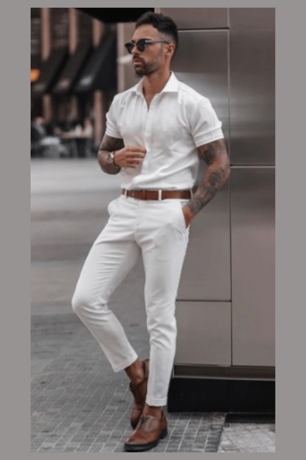 man leaning on wall in all white button up shirt and white pants.  cool summer outfit