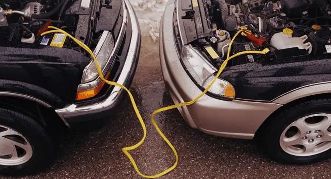 two cars connected by jumper cables. to show how to jumpstart a car