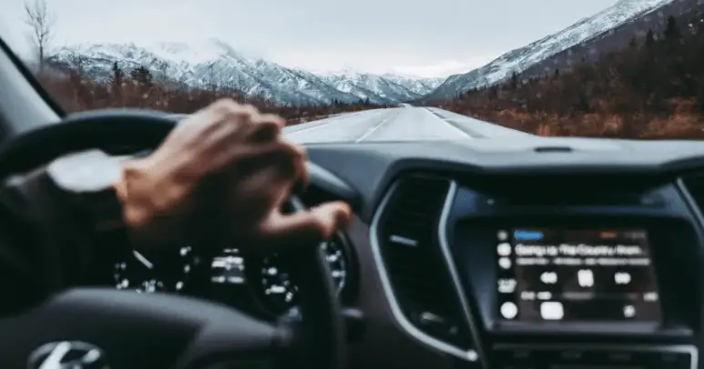 picture of a person driving there car after they had their car jumpstarted.