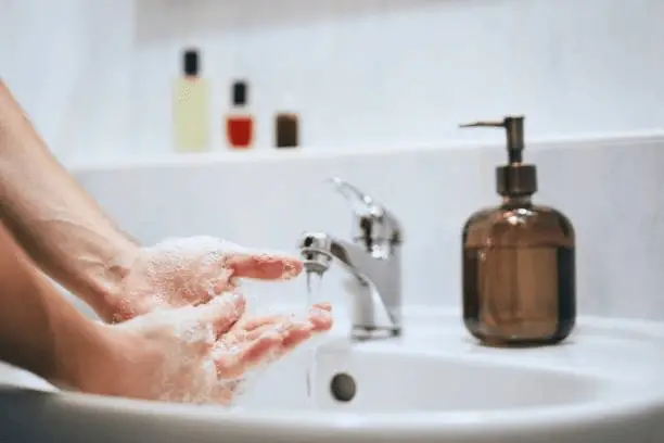 man washing hands with soap 